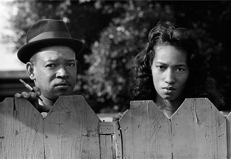 Couple Watching Peace March Over Fence, Oakland, CA 1965